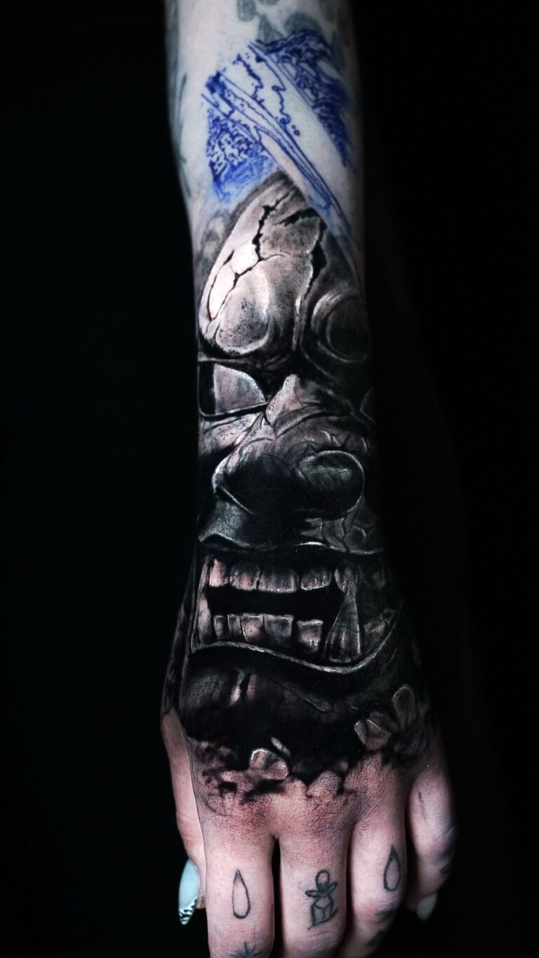 Cover Up Tattoo auf Hand und Unterarm im Black and Grey Stil mit dunklem Maskenmotiv im Art MF Tattoo Studio Siegburg.